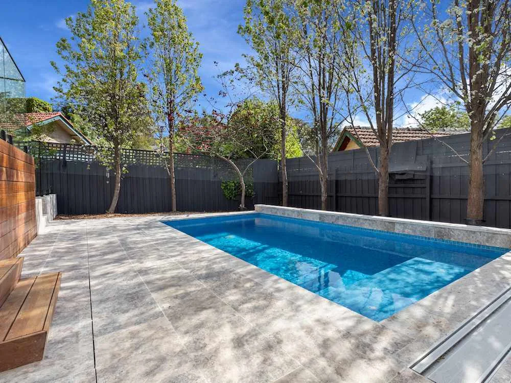 A finished residential pool with clear water and a clean surround.